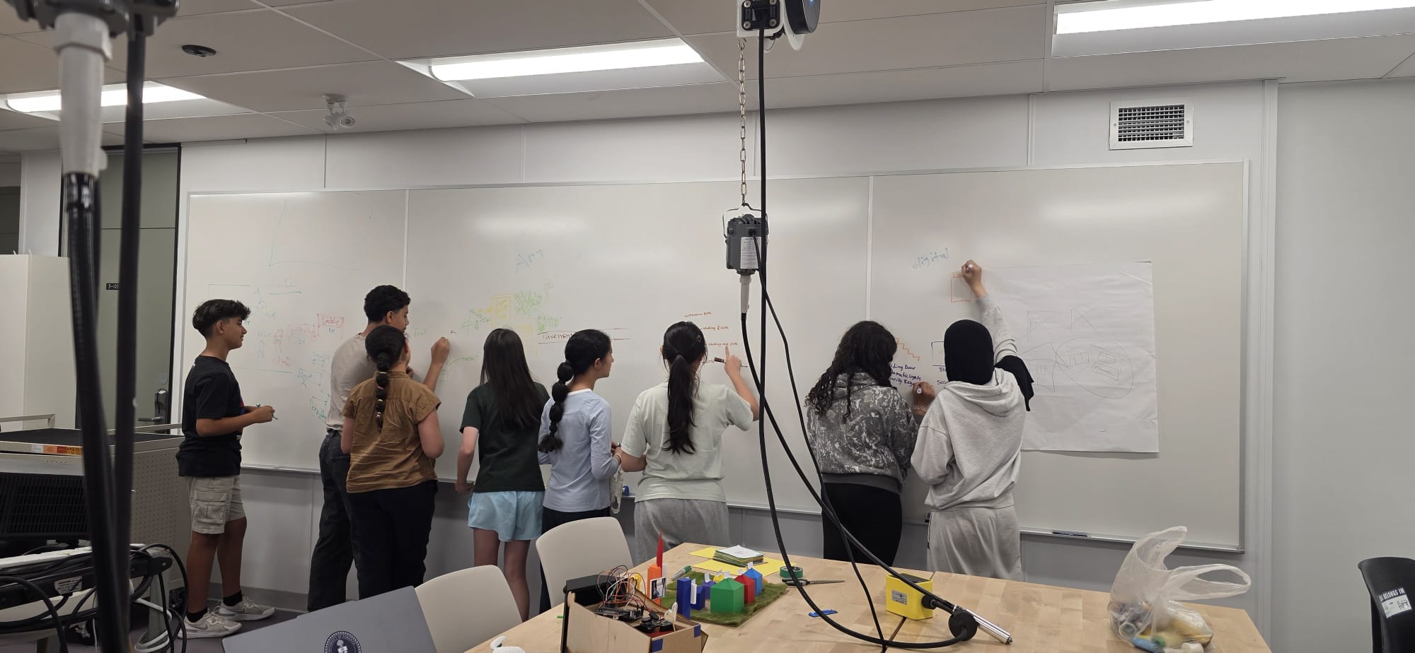 A student sketching and planning their design on a whiteboard